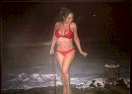 De biquíni, Mariah Carey passeia com o cachorro na neve