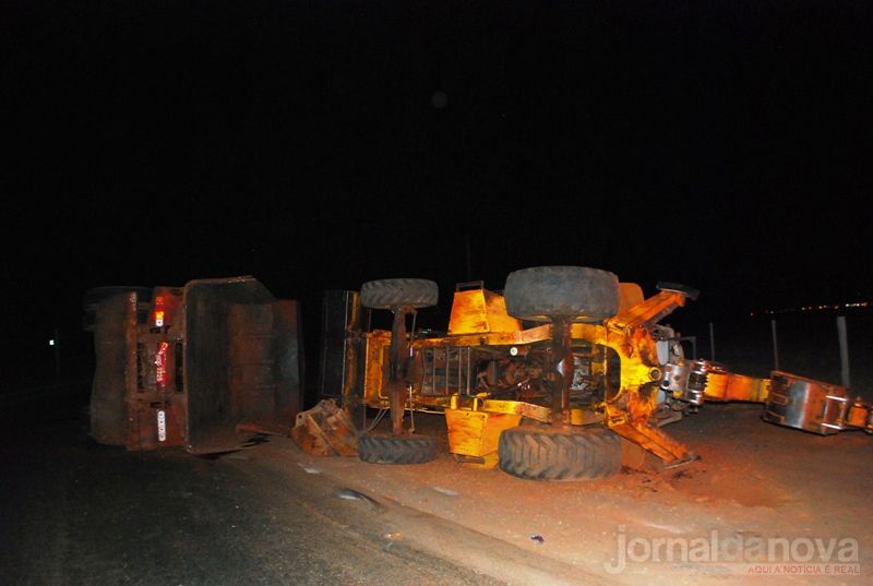 Caminhão carregado com retroescavadeira tomba na rotatória de Santa Rita do Pardo
